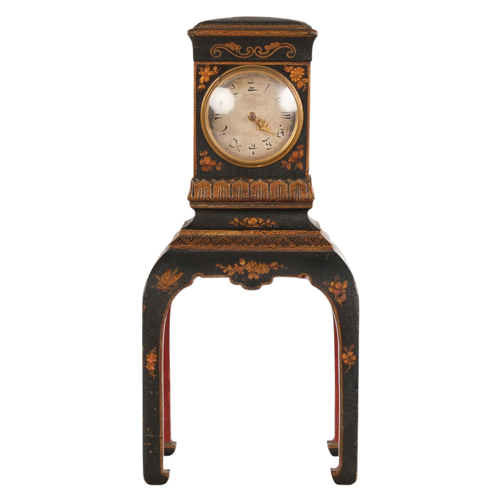 Antique French Lacquered Chinoiserie Bracket Clock: French, an antique chinoiserie bracket clock with black lacquered wood case raised on shaped legs in the form of a miniature table, the interior painted in contrasting red. The case is decorated with