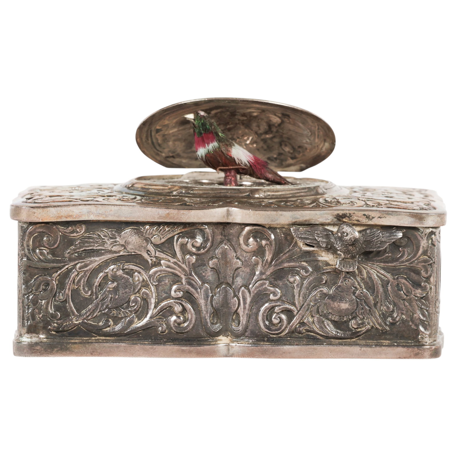 Sterling Mechanical Musical Bird Automaton Box: Antique German style sterling silver musical bird box, featuring a rectangular form with shaped outline, decorated throughout with engraved scrolling foliate motifs. The hinged oval lid opens to revea