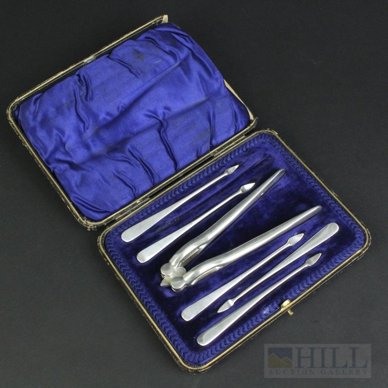 Edwardian English Sterling Silver Nut Cracker Pick Set: Antique Edwardian era English cased nut cracker set. Crafted out of Sterling Silver. Features a sturdy hand held nut cracker and Five nut picks. Housed in a blue velvet lined case. Each bears Sheffiel