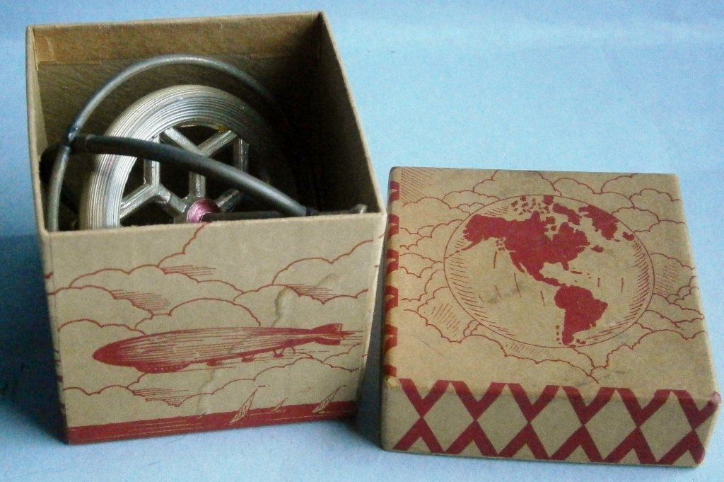 Old Gyroscope in Original Decorative Box from 1930’s: Old Gyroscope in Original Decorative Box from the 1930’s manufactured in USA, 4 in. tall and made of die cast metal in a wire frame, great box art depicting different modes of transportation in the 