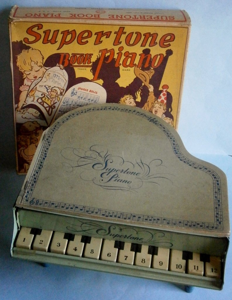 Supertone Book Piano by Louis Marx & Co., Inc. in Origi: Supertone Book Piano by Louis Marx & Co., Inc. in Original Box, copyright 1939 & 1941, made of lithographed tin with wood legs, box is 9 1/2 x 9 1/2 in, book in very good condition, tin shows some wea