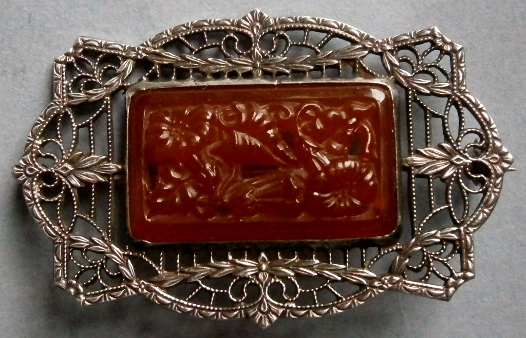 Sterling Silver Filigree Pin/Brooch with Carved Stone: Sterling Silver Filigree Pin/Brooch with Carved Stone signed KB, vintage, 1 3/4 in. wide, stone appears to be carved carnelian with floral and pierced decoration, very well done with intricate pattern