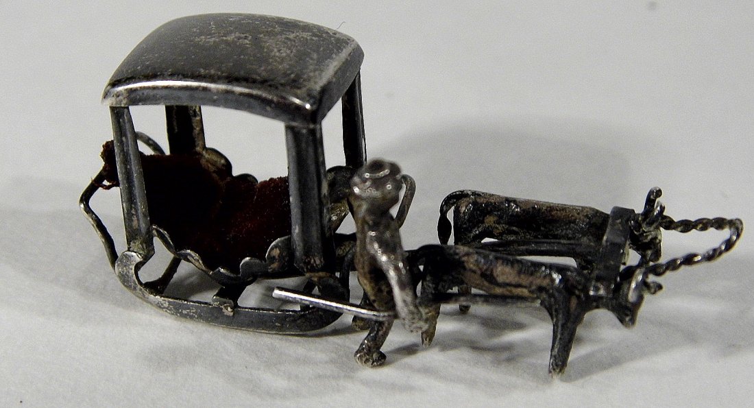Miniature Chinese Pendant Charm Sleigh Carriage Hearse: Appears to be a pair of Asian oxen (horns turn inward) pulling a type of carriage with blade/sleigh locomotion. Footman is carrying a staff to control the animals. No occupant. Interior has some remna