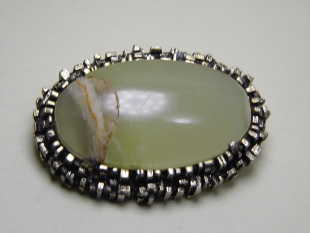 British Miracle Brooch Onyx Stone: Distinctive and unique modern gothic mount encasing onyx stone. Stone has a fissure. Here a link to Miracle jewelry: https://www.miraclejewellery.co.uk/