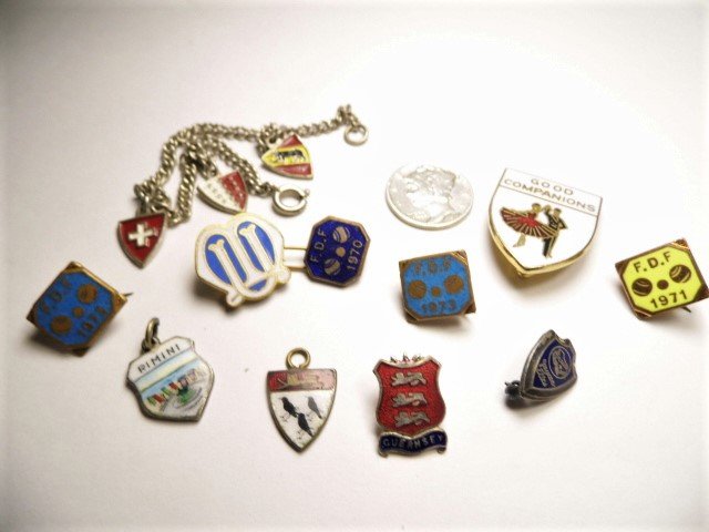 Nine Odd Vintage Lapel/Collar Pins Charms & Bracelet: 10 items total. American, Swiss, Italian, English. A Guernsey pin. A heraldic charm with a lion above three ravens. A dance partners companions pin. A Swiss bracelet. A tourist charm from Rimini, Ital