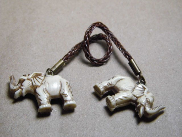 Vintage Plastic Me Be Guessing: Somebody please tell me what this is. A pair of faux ivory charms on each end of a little less than three inch woven length. No way to fasten it, even around the tiniest baby arm.