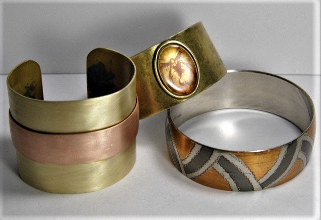 3 Cool Vintage Mixed Metal Bracelets 2 Cuffs 1 Bangle: Two cuffs, one all brass with a captured pixie. The other is a mix of brass and copper. The bangle is a nice mix of copper and what appears to be a dark and lighter pewters.
