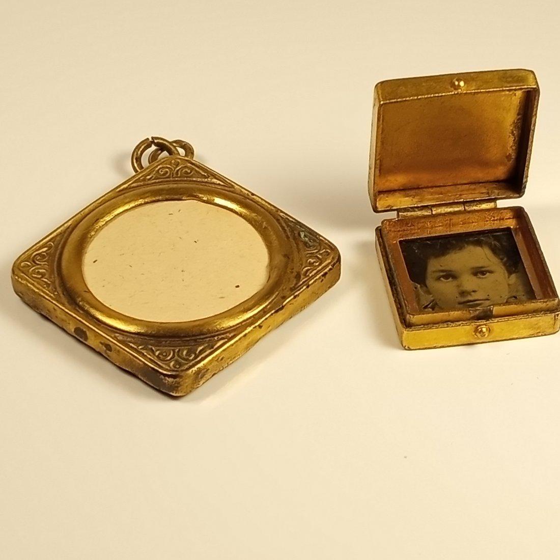 Pair Antique circa 1930's Photo Lockets: Box locket is gold plated. Closes tight. Good hinge. Back of frame locket is gutta percha.