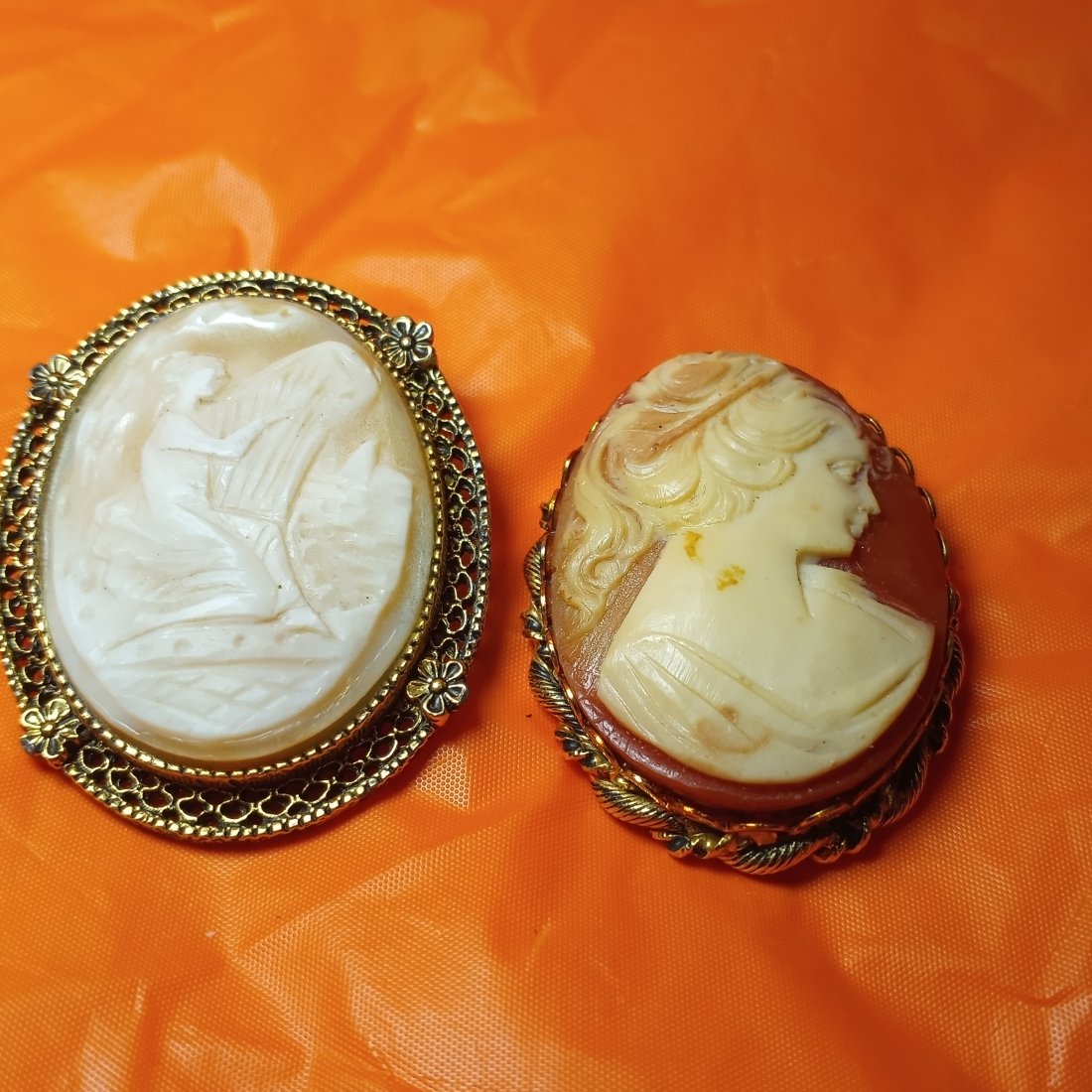 Pair Large Vintage Cameo Pins: One with lady and harp is genuine carved shell cameo in a nice bezel. The portrait cameo is composition/resin. Also has a nice frame.