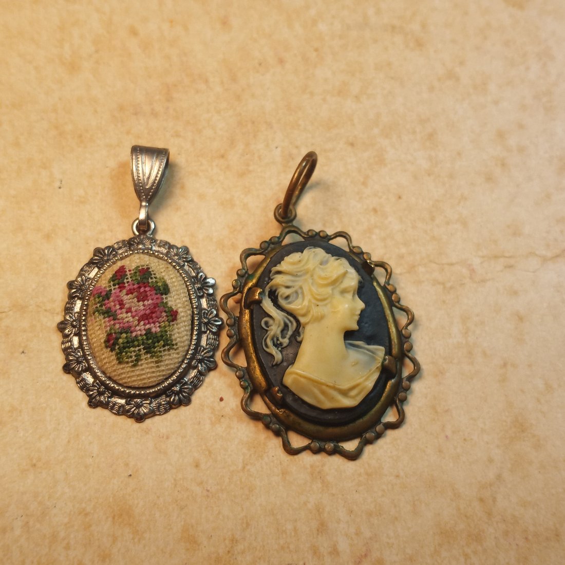 Pair Necklace Pendants: A faux cameo and cross stitch pendant. From the 1980's. Both have bails.
