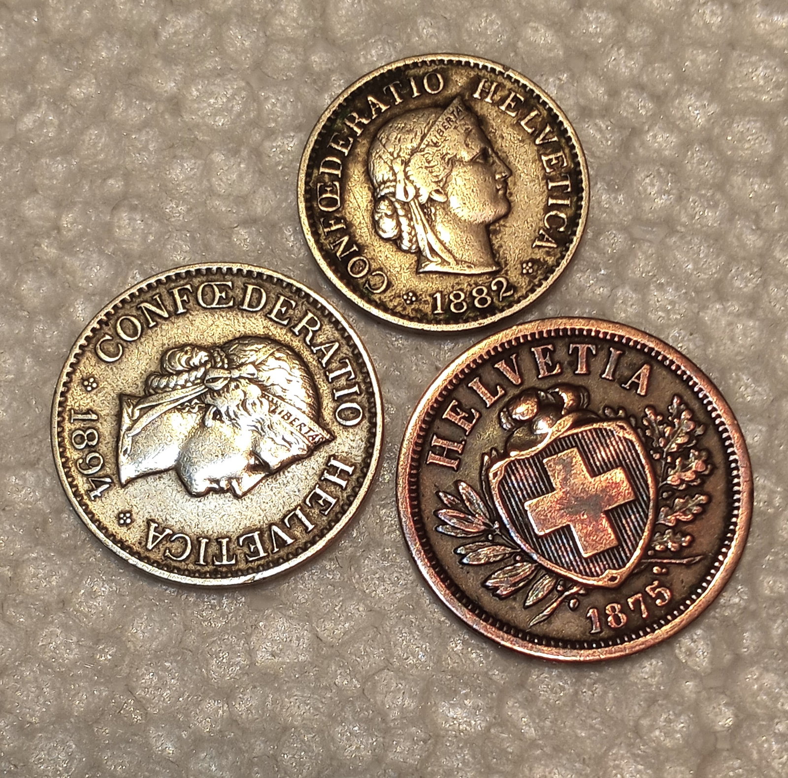 Three 1800's Switzerland Coins: Two of the coins (1882,1894) are nickel alloy, and the third (1875) is copper. Conferderatio Helvetica Confederation of Helvetians) is the latin name for Switzerland.