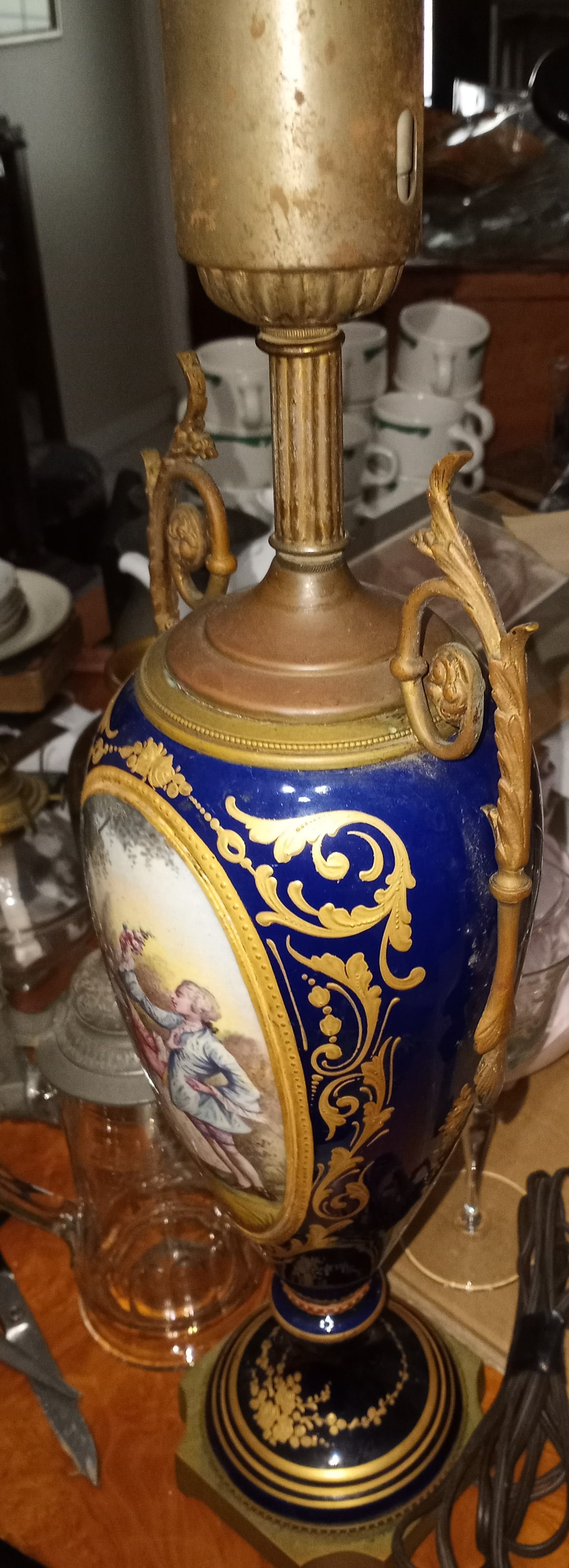 Circa 1870's French Heavy Gilt Porcelain Lamp: Paintings on both sides, not transfer work. Burnished gold paste, probably considerable gold content. Bronze base., not copper or brass. Originally ran on DC current. Has an adapter socket. Sold as de
