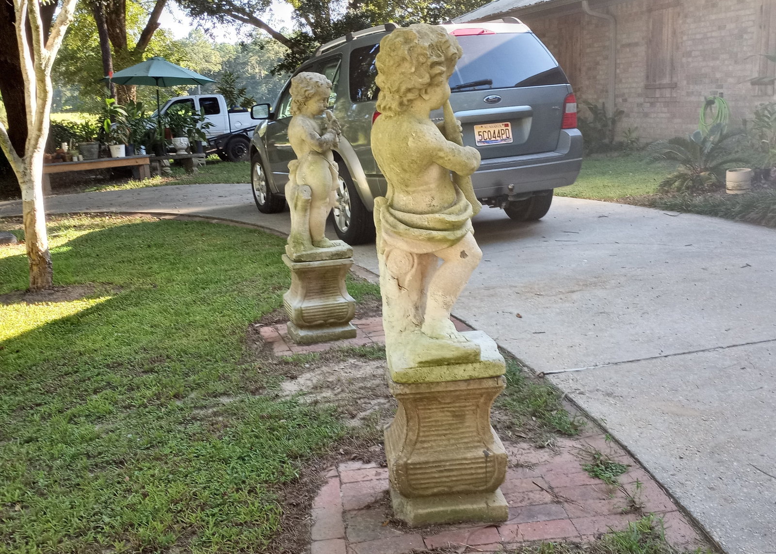 Antique Italian Baroque Trio of Vicenza Stone Putti Minstrels: Carved Italian limestone with fossilizations. Pedestals/columns are concrete. About five feet tall.