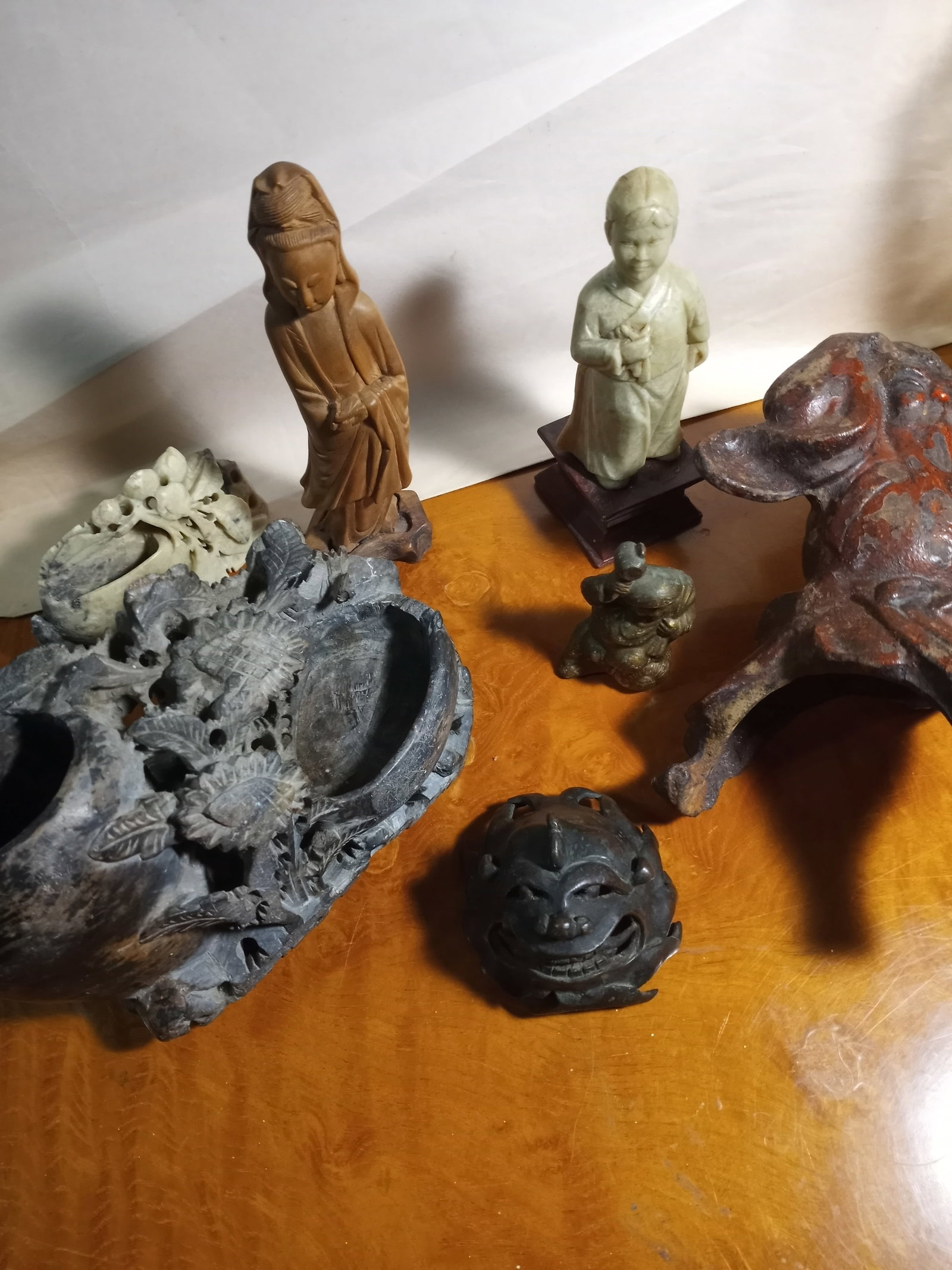 Lot of Asian Hardstone Bronze and Cast Pieces Sandalwood Boddhisattva: Seven items. Two inkpots, a statue of a young scholar, a sandalwood carved statue. A small sitting buddha. Only the cinnabar buddha and the bronze grotesque are damaged. All the others are whole. Box 