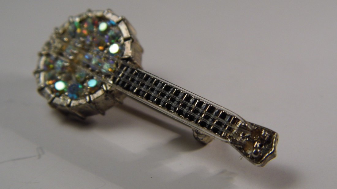 Designer Costume Rhinestones Stringed Banjo Pin: Designer signed and copyright illegible. Measures about 2 inches. Instrument is strung, but does not play. Cute.