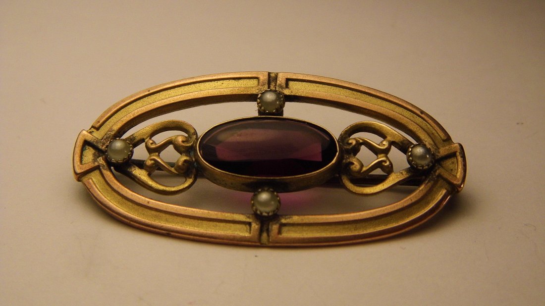 Amethyst & Seed Pearl Edwardian Pin: Small pin with an amethyst cabochon and 4 well set seed pearls. Cabochon is smooth on the front and cut on the back.Measures 1 3/4 inches.