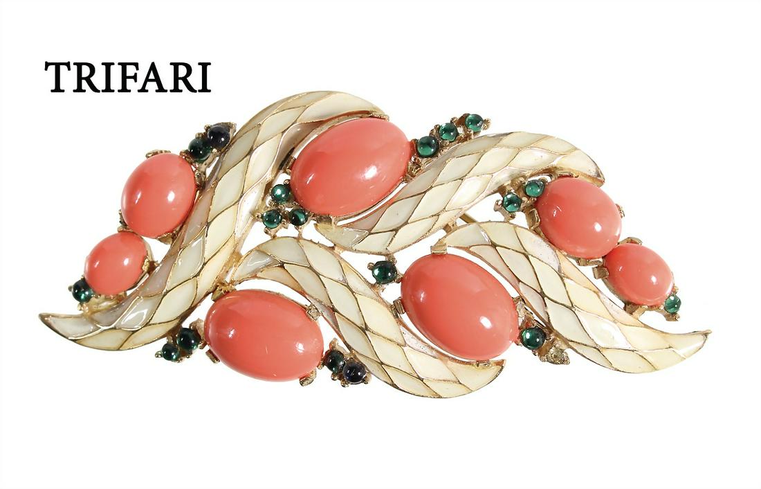 brooch, metal yellow, signed TRIFARI, 7 oval coralline: brooch, metal yellow, signed TRIFARI, 7 oval coralline cabochons, accentuated green glass, cream-colored enamel coating, c. 76.0 x 32.5 mm German Description Brosche, Metall gelbfarben, sig. TRIFARI,