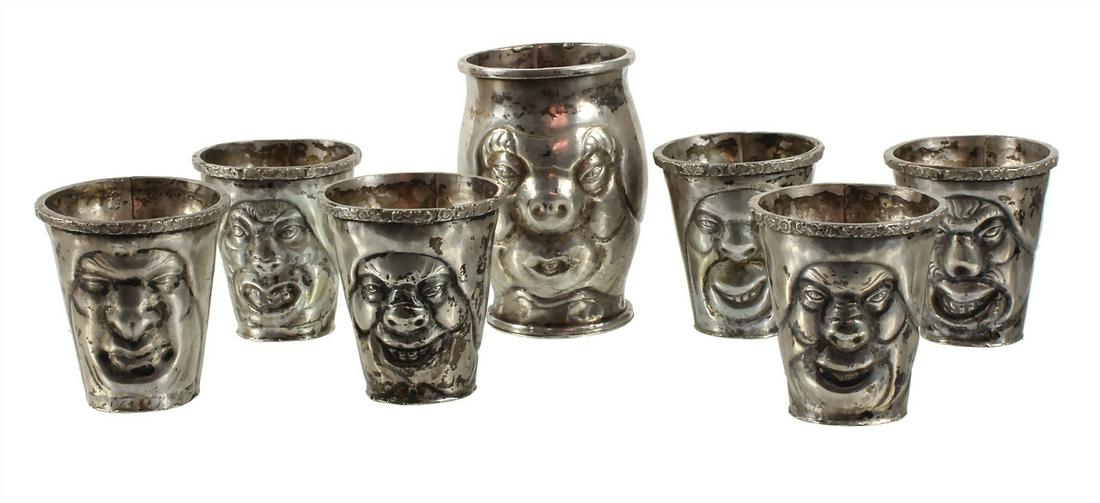 seven curious mugs, silver (tested), 6 small and  1 larger mug with quirky  relieflike worked faces, (1 of 1)