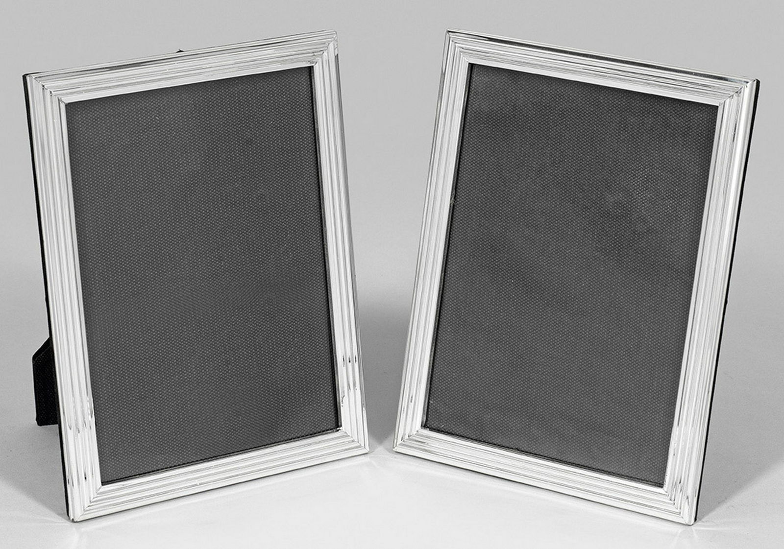 Paar Tischbilderrahmen: Rechteckig. Mehrfach linear profilierter Rand. Rückseitig aufstellbar. Gest. 925. 21 cm x 16 cm. Bildausschnitt 18 cm x 13 cm. A pair of Sterling silver photo frames. Standard mark 925. Sterling-Silb