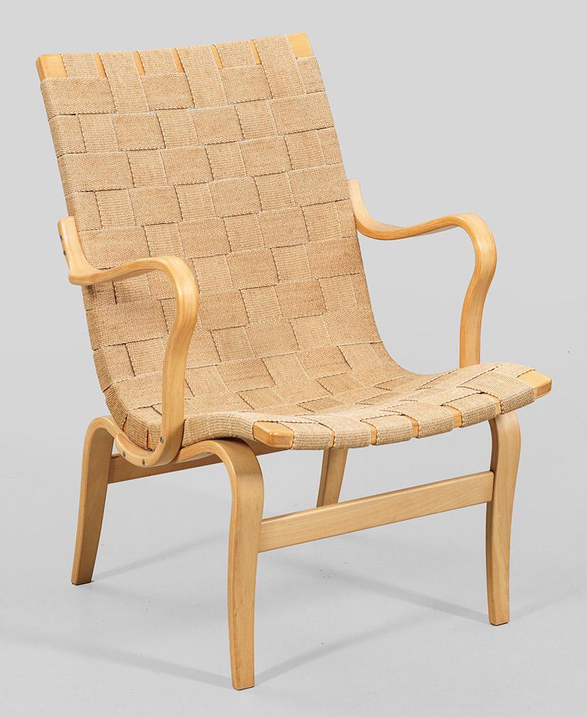 Eva Chair von Bruno Mathsson: Helles Buchenholz und Gurtband. Gestell aus teilw. gebogten Streben und geraden Stegen. Geschwungene Sitzfläche in Rückenlehnenrahmung übergehend. Bespannung aus geflochtenem Gurtband. Entwerfer un