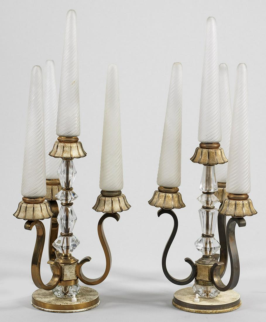 Zwei Art Déco-Tischlampen: 4-flg.; Messing, teilw. weiß-gold gefasst, farbloses Kristallglas sowie farbloses satiniertes Glas. Über flachem Rundsockel mehrfach gegliederter Balusterstaft. Unterhalb davon ausgehend dre