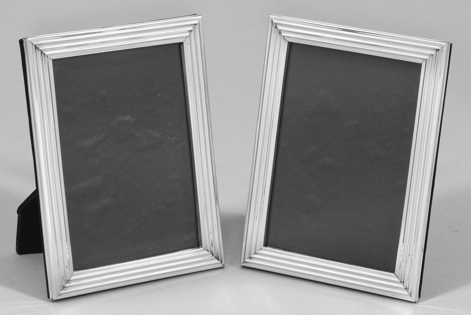 Paar kleine Tischbilderrahmen: Silber. Rechteckig mit profiliertem Rand. Rückseitig aufstellbar. Gest. 925. 18,5 cm x 13,5 cm. Bildausschnitt: 15 cm x 10 cm. /V/A pair of Sterling silver photo frames. Standard mark 925.// /T/S