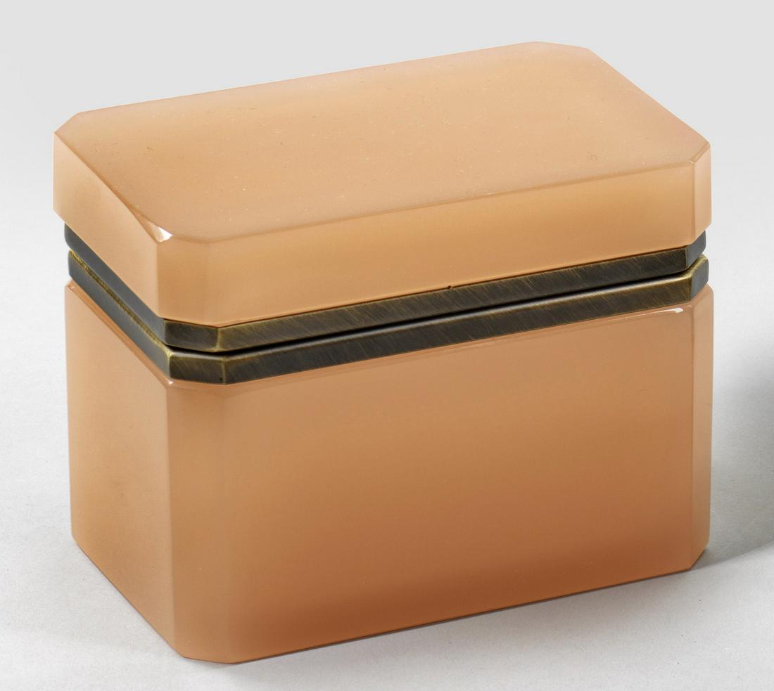 Art Déco-Dose: Quaderform mit abgeschrägten Ecken. Rosafarbenes Opalglas, geschliffen und poliert. Scharnierte Messingmontierung. H. 10,2 cm. 13,3 cm x 8,7 cm. A French Art Deco cut pink-coloured glass box with
