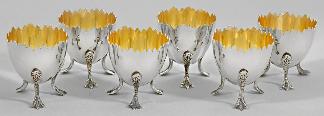 Sechs Eierbecher: Silber. Dekorativ in Form eines aufgebrochenen Eis gestalteter Korpus auf Krallenfüßen. Innen vergoldet. Gest. 925. Gew. zus. ca. 285 g. H. 5,5 cm. Six decorative Sterling silver egg-cups. G