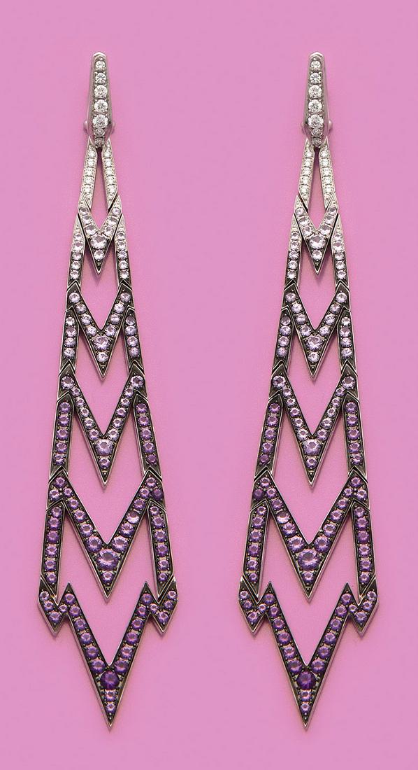 Paar Chandeliers von Stephen Webster: aus der Kollektion "Lady Stardust". Weißgold, gest. 750. Dekorativ gestaltet in Form eines Blitzes in Ajour, besetzt mit violettfarbenen Amethysten von zus. ca. 2,33 ct., Saphiren von zus. ca. 1,