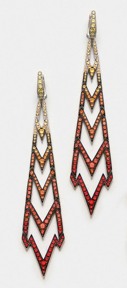 Paar Chandeliers von Stephen Webster: aus der Kollektion "Lady Stardust". Weißgold, gest. 750. Dekorativ gestaltet in Form eines Blitzes in Ajour, besetzt mit roten, gelben und orangefarbenen Saphiren von zus. ca. 3,41 ct. und Brilla