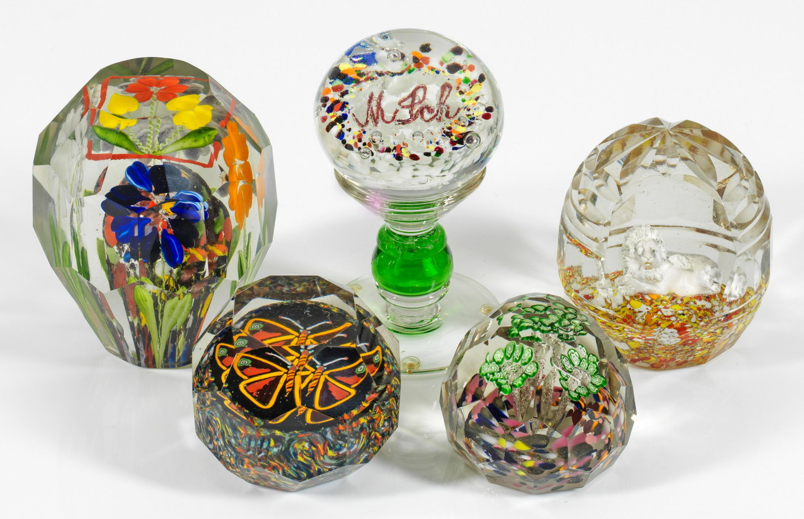 Fünf farbenfrohe Paperweights: Farbloses Glas, teilw. facettiert geschliffen. Polychrome, florale Ziereinschlüsse u. a. in Krösel-Technik und Millefiori-Dekor sowie plastische Darstellung eines Löwens bzw. Besitzer-M