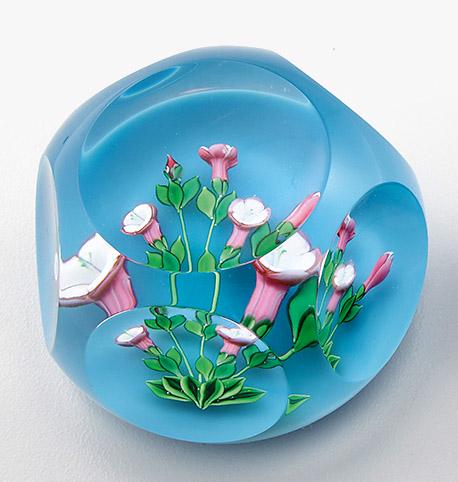 Paperweight "Viola" von Saint-Louis: aus limitierter Edition. Farbloses Glas mit Fensterschliff. Auf hellblauem Grund eine dreidimensional gearbeitete Blume mit rosafarbenen Blüten. Limitierte Auflage 135/250. Herstellerzeichen mit 