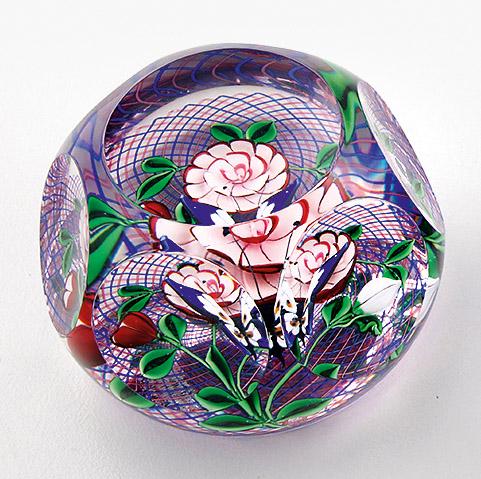 Paperweight "Papillon" von Saint-Louis: aus limitierter Edition. Farbloses Glas mit Fensterschliff. Dreidimensionale Darstellung eines fliegenden Schmetterlings über einem Blumenbouquet auf roten und blauen Spiralfäden. Limitierte