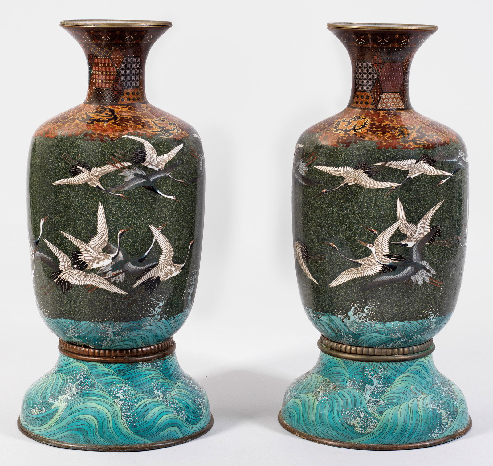 Paar große Cloisonné-Vasen mit Kranichdekor: Messing und Kupfer mit polychromen Email-Cloisonné. Über geschweift hochgezogenem Rundsockel balusterförmiger Korpus, in schmalen Hals mit weit ausgestelltem Lippenrand übergehend.
