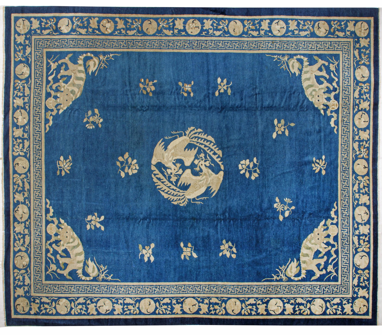 Antiker Peking-Teppich: Antiker Peking-Teppich China. Peking. Um 1920. Wolle auf Baumwolle. Im blauen, monochromen Innenfeld Zentralmedaillon aus Phönixpaar sowie lose gestreute Blüten. In den Ecken große Tige