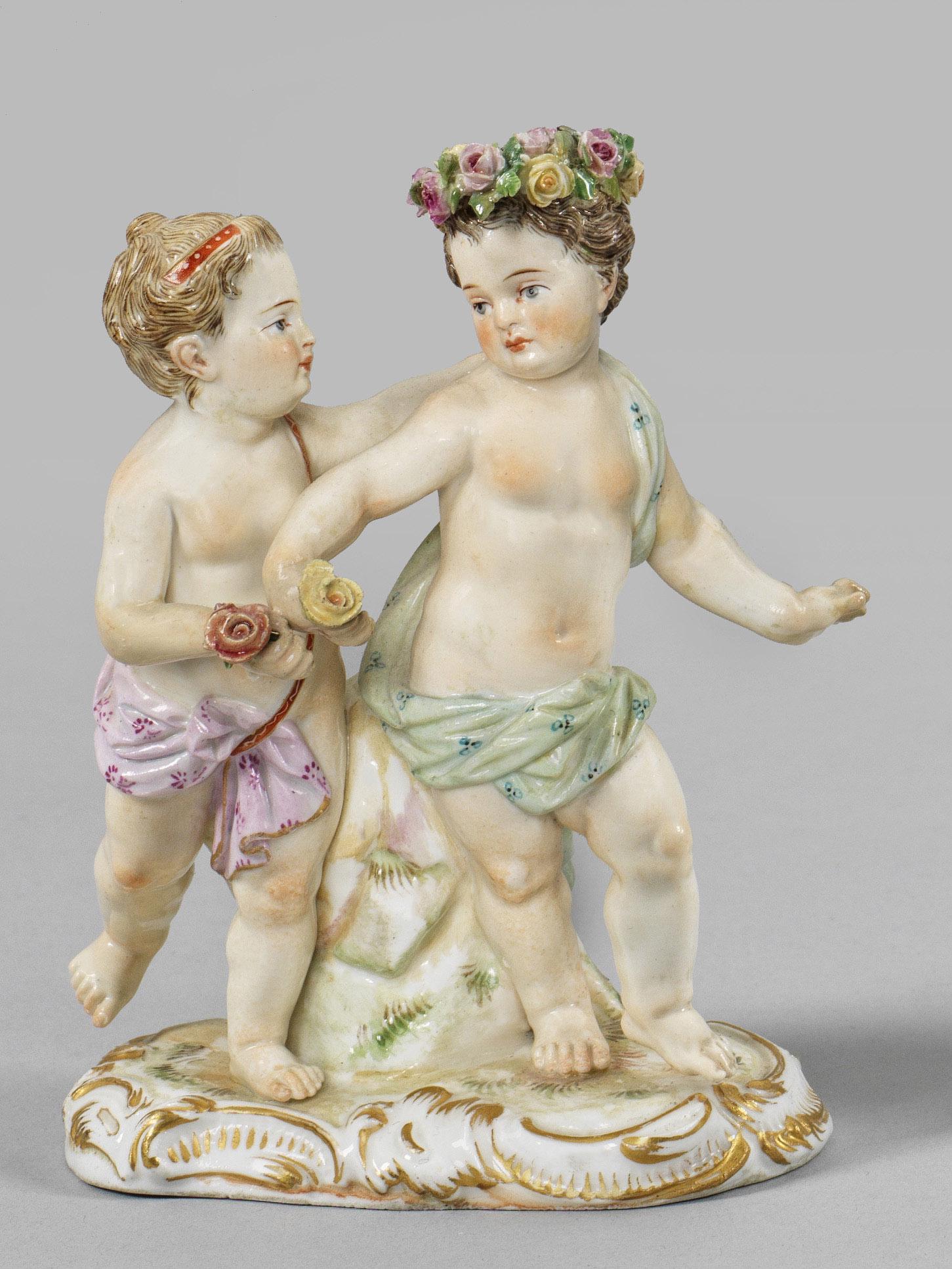 Genienpaar: Genienpaar Auf rocaillereliefiertem Sockel stehendes Mädchen, sich einem Knaben mit Blumenkranz und -strauß zuwendend. Polychrome Malerei mit Goldstaffage. Entw. Carl Christoph Punct. Modell