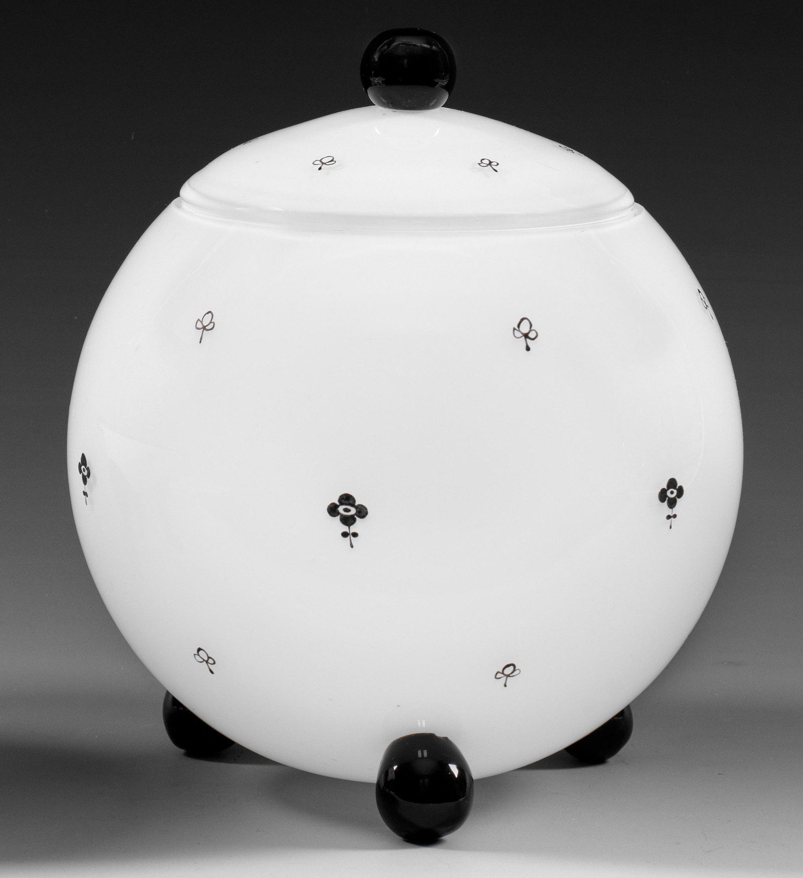 Dose (Bonbonniere) von Loetz: Kugelform auf drei Kugelfüßen, korrespondierender Knauf. Weißes Opalglas, farblos überfangen, Füße und Knauf aus schwarzem Glas. Dekor "Ausführung 170" aus gestreute