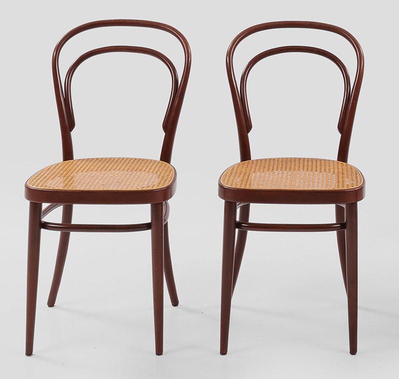 Paar Caféhaus-Stühle von Thonet: Modell 214. Buchenholz, rotbraun gebeizt. Gestell aus gebogten Rundstäben sowie Sitzfläche aus Rohrgeflecht. Schlagstempel Thonet 82 sowie Papieretikett. Entw. Michael Thonet, 1859. Sitz-H.
