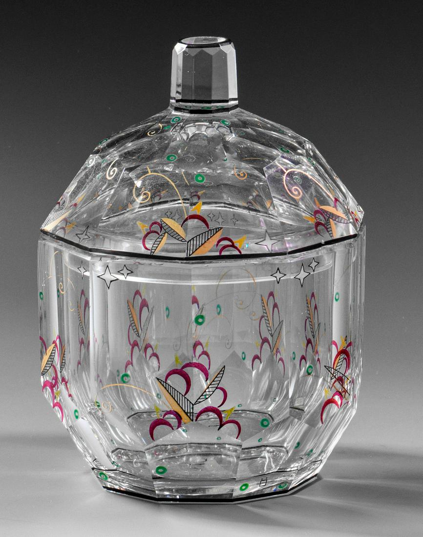 Art Déco-Zierdose von Johann Oertel & Co.: Farbloses Kristallglas mit Facettenschälschliff. Dekor in farbiger Emailmalerei und Gold. Entw. Glasfachschule Haida. Gemarkt "Ö". H. 14,5 cm. Provenienz: Aus dem Nachlass Dr. Zahn, Norddeut