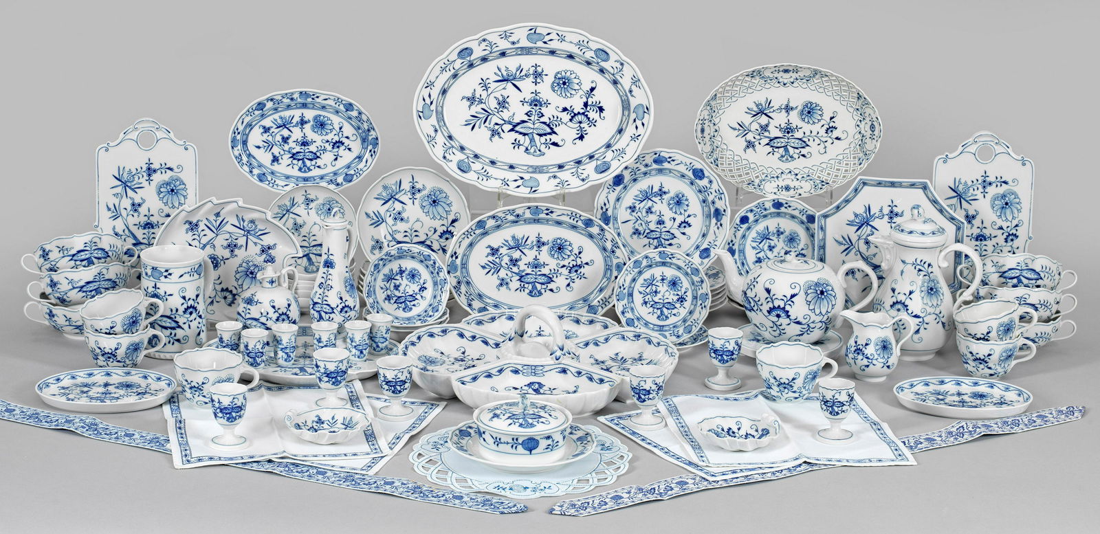 Umfangreiches Service mit Zwiebelmusterdekor: 64-tlg.; Kaffee-, Teekanne, Kannenuntersetzer, Sahnegießer, 6 Kaffee-, 6 Suppentassen mit Untertassen, 6 Kuchen-, 3 Brot-, 2 Konfektteller, 3 Beilagenplatten, Gebäck-, Konfektschale, 3 Desse