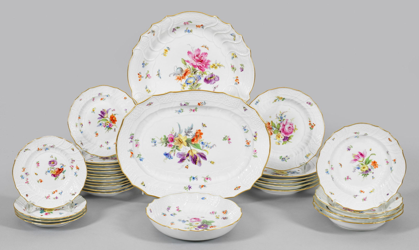 Speiserestservice mit Blumendekor: 29-tlg.; Anbietplatte, 2 Beilagenschalen, 4 Brot-, 6 Speise-, 4 Suppen-, 12 Dessertteller. Reliefdekor "Neubrandenstein" sowie farbenfrohe Blumenmalerei. Goldrand. Teilw. minim. best./ber.; Schwerterm