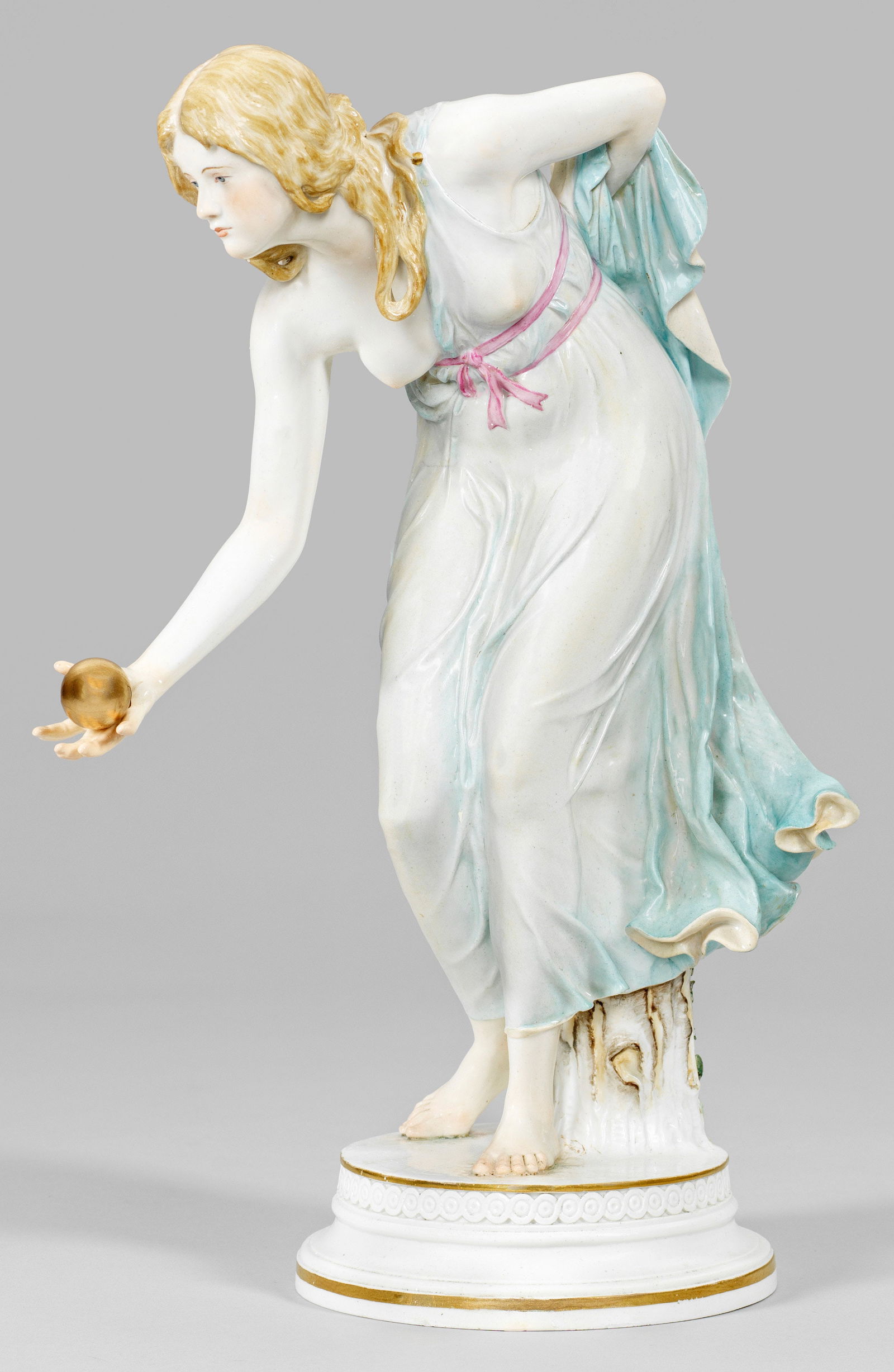 Jugendstil-Figur "Kugelspielerin" von Walter Schott: Runder profilierter Sockel mit Flechtbandbordüre. Stehendes Mädchen in einem hauchdünnen, türkisblau staffierten Kleid, in ihrer rechten Hand eine goldene Kugel zum Wurf haltend. P