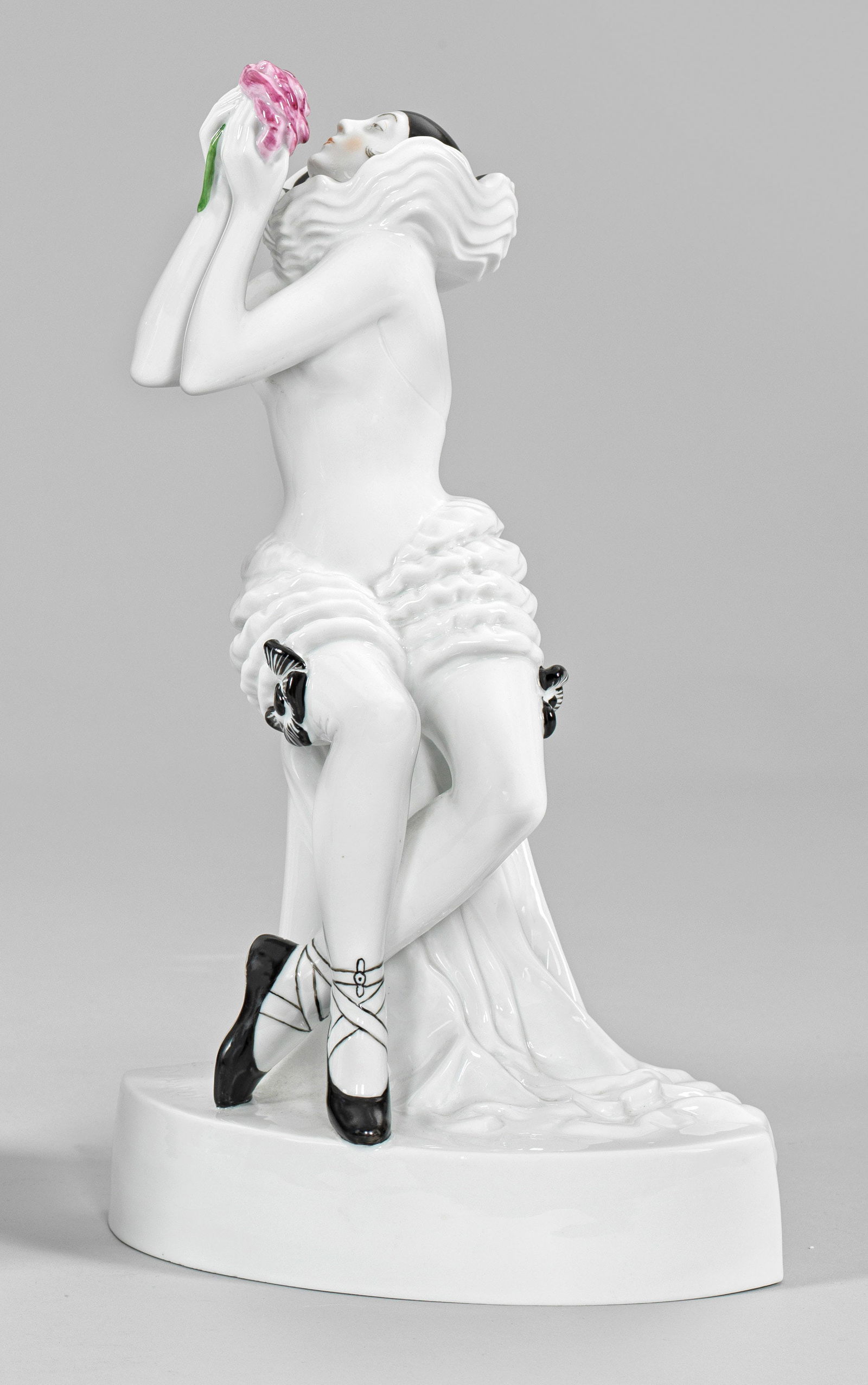 Colombine (oder Pierrette) mit Rose: Neuausformung eines Art Déco-Modells der Schwarzburger Werkstätten. Über linsenförmigem Sockel, auf einem Podest sitzende, nach oben blickende Colombine in enganliegendem Kostü