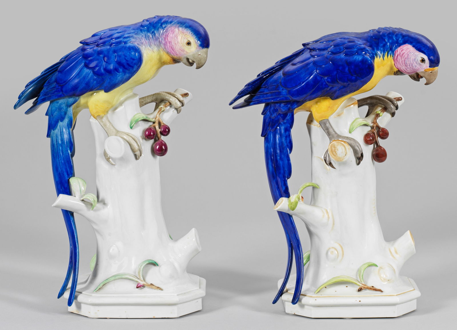 Paar große Tierfiguren "Papagei mit Kirschzweig": Spätere Ausformung eines Art Déco-Modells der Schwarzburger Werkstätten. Über achtfach gekantetem Sockel, auf stilisiertem Baumstumpf sitzender, farbenprächtiger Papagei mit K