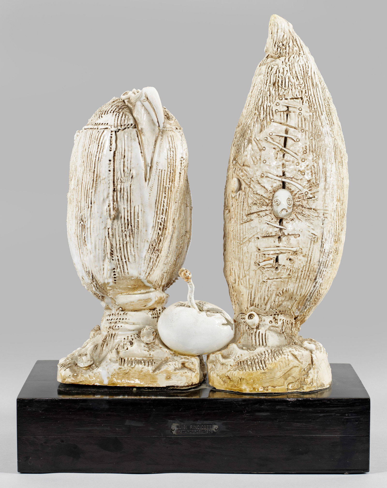 Luigi Rincicotti: (Geb. 1941 Fano/Italien) "Metamorfosi" (Metamorphose). Originaltitel 3-tlg., montierte, weiß glasierte, surrealistische Keramikgruppe auf ebonisiertem Holzsockel, 1976. Sign. u. nummeriert 36/100