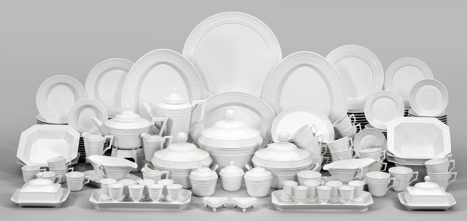 Kaffee- und Speiseservice "Kurland": Weißporzellan. 152-tlg.; Stövchen, Kaffee-, Teekanne, 3 Zucker-, 2 Butterdosen, 3 Sahnegießer, 5 Mokka-, 18 Kaffeetassen mit Untertassen, 16 Speise-, 12 Suppen-, 15 Brot-, 20 Kuchen-, 1