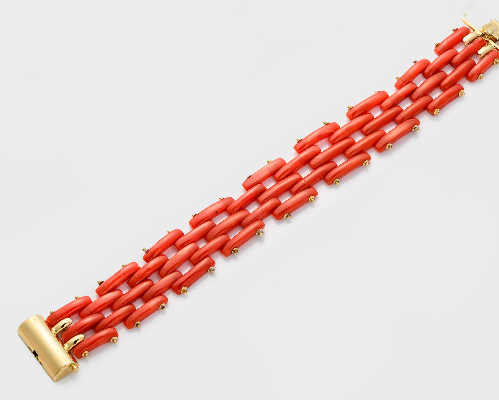 Cocktail-Korallen-Armband: Gelbgold, gest. 750. Breite Bandform aus versetzt angeordneten, stäbchenförmigen Gliedern. Coral bracelet, clasp in 18 k gold.