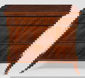 Biedermeier-Kommode mit Poudreuse-Einteilung: Mahagoni, furniert. Weißer Marmor und Bronze. Gerader, rechteckig angelegter Korpus, flankiert von eingestellten Halbsäulen auf geschweiften Beinen. In der gegliederten Front ausziehbare Abstellflä