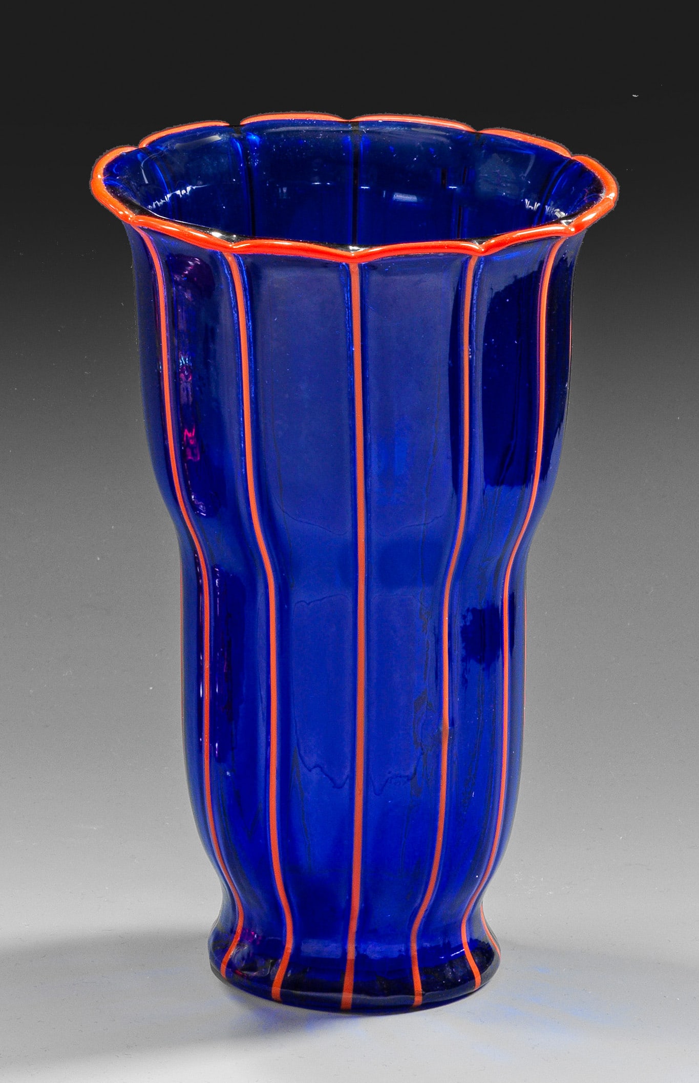 "Tango"-Glasvase von Loetz: Hohe, geschweifte Glockenbecherform mit vielfach gewelltem Lippenrand. Dekor "Ausführung 157" in sog. "Tangofarben" aus dunkelblauem Glas mit aufgelegten vertikalen Fäden und akzentuiertem Lippenran