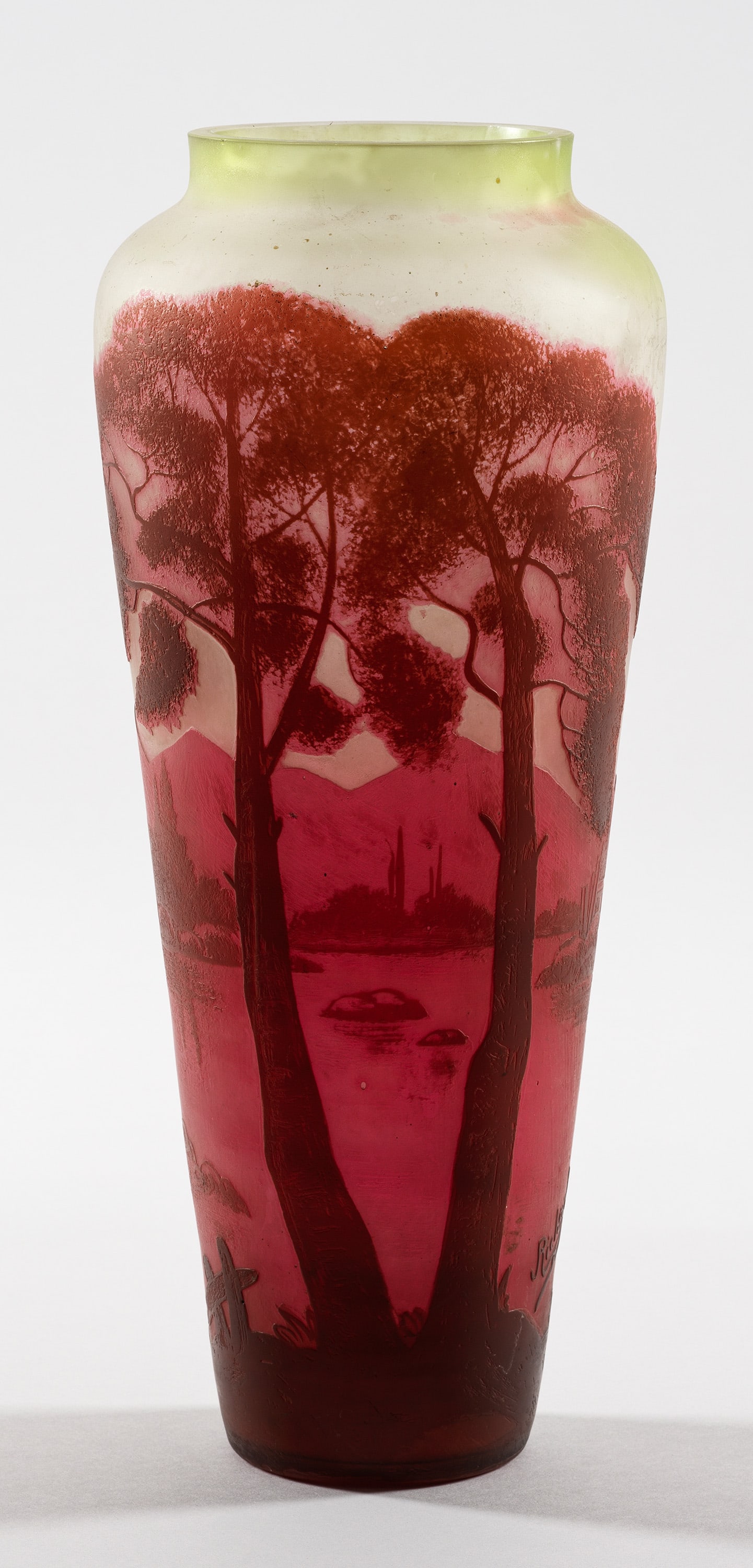 Große Loetz-Ziervase mt Flusslandschaft: Überfangglas, farblos, hellgrün und bordeauxrot. Umlaufender, in mehreren Arbeitsgängen geätzter Dekor aus einer von Bergen umsäumten Flusslandschaft, beeinflusst von Gallé und Daum Frères. Sig